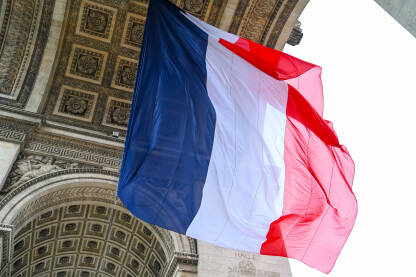 Zastava Francuske vijori se na vjetru. Francuska zastava na Slavoluku pobjede u Parizu. Nacionalna zastava Francuske.