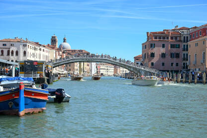 Turisti na mostu u Veneciji, Italija. Historijske građevine i riječni kanali.