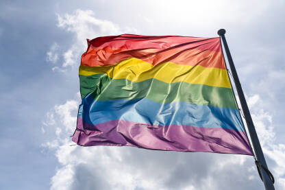 LGBTIQ zastava se vijori na vjetru na jarbolu u gradu.