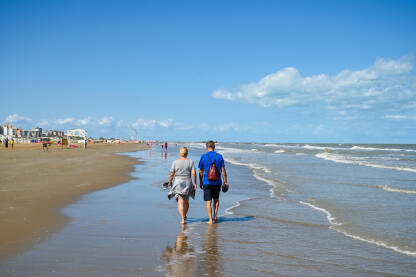 Par šeta pješčanom plažom uz more.