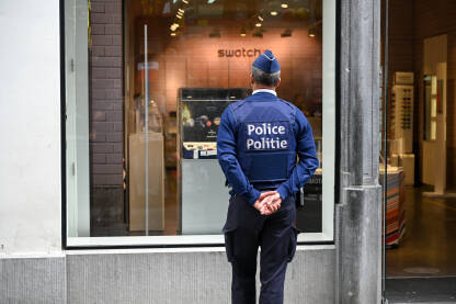 Policajac u Belgiji. Policajac u Belgiji gleda u izlog. Policija Belgije.