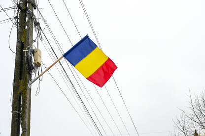 Državna zastava Rumunije na banderi. Plava, žuta i crvena boja rumunjske zastave.