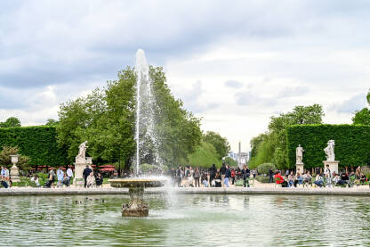 Pariz, Francuska: fontana Grand Bassin Rond. Grupa ljudi koji šeta vrtom Tuileries. Turisti istražuju grad.