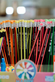 Na polici knjižare raznobojne drvene olovke. Svaka olovka ima svoju jedinstvenu boju, stvarajući šarenilo koje privlači pažnju.