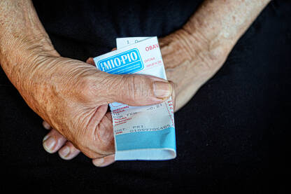 Ruke penzionera koje drže penzionerski ček FZ MIO/PIO.