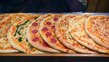 Ukusna pizza servirana u restoranu. Brza hrana. Mnogo različitih vrsta italijanskih pizza na stolu.