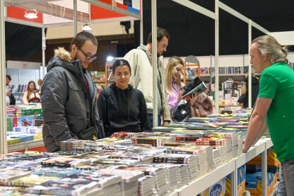 Posjetioci na sajmu knjiga. Ljudi biraju i pregledavaju knjige. Zbirka knjiga na štandu. Sarajevski sajam knjige.