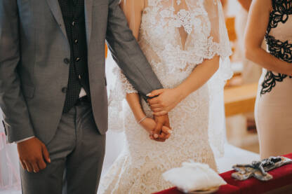 Par se drži za ruke tokom vjenčanja u crkvi