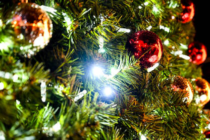 Ukrašena božićna jelka sa LED svjetlima i ukrasima od kuglica. Šareni ukrasi i lampice na granama zimzelenog drveća.