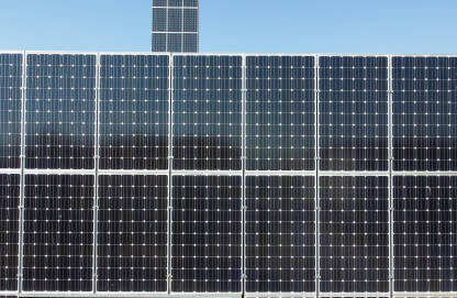 Solarni paneli na krovu objekta. Snimak dronom na solarne panele na vrhu zgrade. Proizvodnja čiste obnovljive energije iz sunca. Fotonaponske solarne ćelije. Električna energija.