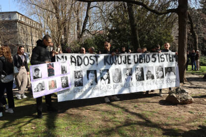 Grupa mladih ljudi na protestima u Sarajevu drži veliki transparent s fotografijama stradale djece i natpisom