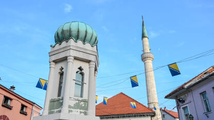 Tuzla, Bosna i Hercegovina. Glavni trg u centru grada. Minaret i džamija. Zastava Bosne i Hercegovine.