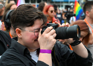 Djevojka sa kamerom. Žena sa fotoaparatom na protestu. Fotografkinja.