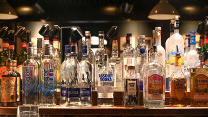 Različite vrste alkoholnih pića na polici u kafiću. Žestoka alkoholna pića. Vodka, tequila, whiskey.