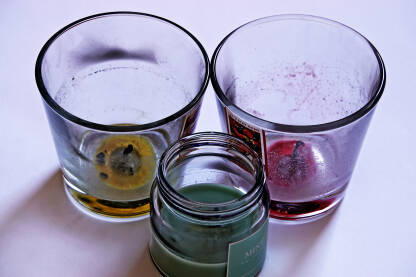 Tri dogorjele mirisne svijeće u staklenim posudama.