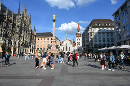 Minhen, Bavarska, Njemačka. Ljudi šetaju glavnim trgom u centru grada. Marienplatz. Zgrada stare i nove Vijećnica.