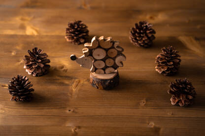 Drvena igračka jež i šišarke na drvenom stolu, jesen