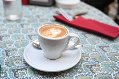 Espresso kafa sa mlijekom servirana na stolu u restoranu.