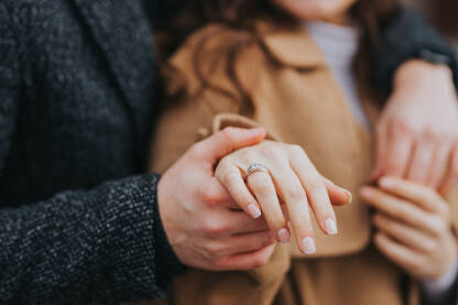 Par se drži za ruke, pokazuju zaručnički prsten
