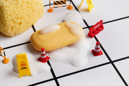 Ilustracija poda kupaonice sa sapunom, pjenom i predmetima za označavanje klizavog poda.