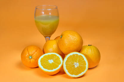Narandže i čaša cijeđenog soka