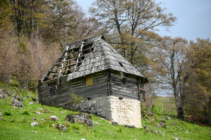 Napuštena stara kuća na planini. Napuštena stara kuća na planini. Trošna kamena i drvena kuća na selu.