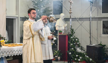 Zagreb, Hrvatska: Katolički svećenici u liturgijskom ruhu se mole. Svećenik zamahuje kadilom. Kršćanski svećenici se mole u katedrali. Misa polnoćka u crkvi.