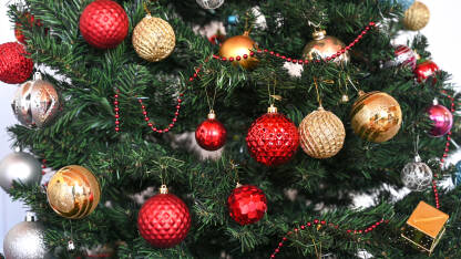Okićeno novogodišnje i božićno drvo. Šareni ukrasi i kuglice.