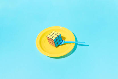 Rubikova kocka na žutom plastičnom tanjuru.