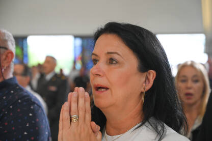 Vjernica tokom molitve u crkvi. Žena drži sklopljene ruke tokom molitve.