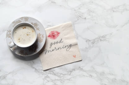 Kafa sa porukom Šoljica kafe sa porukom dobro jutro na salveti i poljupcem.