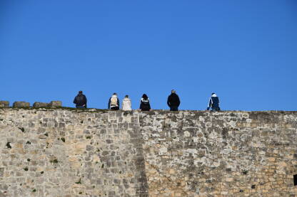 Šest posjetioca na jednom od bedema tvrđave u Jajcu koji gledaju na grad.
