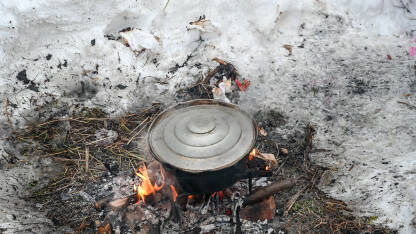 Kuhanje ručka u loncu na vatri u snijegu tokom zime.