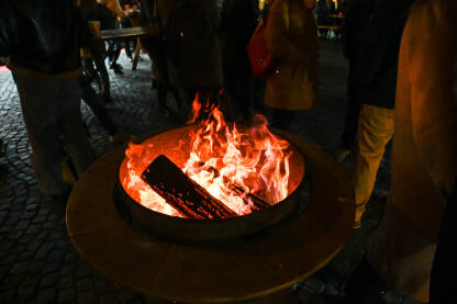Ljudi se griju oko vatre tokom hladne zimske noći