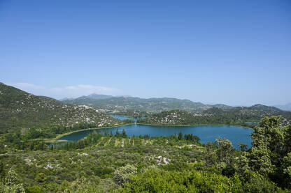 Prirodno plavo jezero između zelenih brežuljaka. Baćinska jezera, Ploče, Hrvatska. Panoramski pogled na Baćinska jezera.