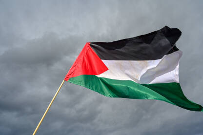 Zastava Palestine. Palestinska zastava naspram oblačnog neba.