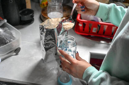 Majka priprema hranu za bebu. Mama priprema flašicu sa hranom za dijete.