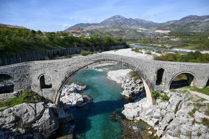 Stari kameni most iznad rijeke. Mesi most na rijeci Kir, Skadar, Albanija. Stari kameni most iznad rijeke. Voda teče ispod mosta. Mesi most na rijeci Kir, Shkoder, Albanija, sagrađen u 18 vijeku. Otomanska arhitektura. Turistička atrakcija.