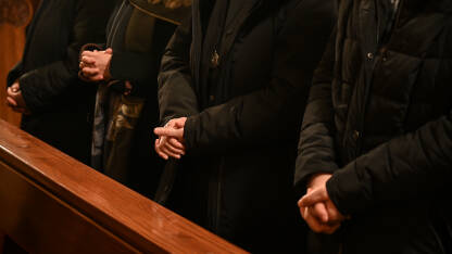 Časna sestra moli prekriženih ruku u katedrali. Božićna misa polnoćka. Katoličanstvo.