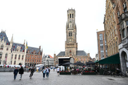 Bruges, Belgija: Market Square. Zgrade u centru grada. Ljudi šetaju trgom.