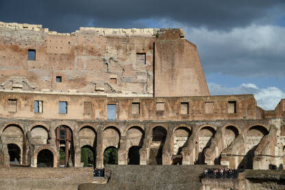 Rim, Italija. Koloseum u centru grada. Turisti u posjeti. Ljudi istražuju jednu od najpoznatijih znamenitosti na svijetu. Rimska arhitektura. Ljudi u Koloseumu.