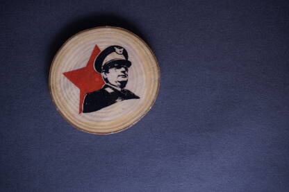 Suvenir s likom Josipa Broza Tita Suvenir s likom Josipa Broza Tita na tamnoj podlozi. Magnet, preslikana slika na komadu drveta. Tito je bio vođa jugoslavenskih partizana i predsjednik Jugoslavije