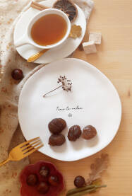 Desert, kandirani kesten u tanjiru na stolu posluzen uz čaj