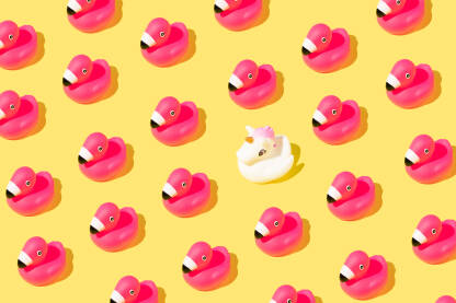 Ljetna pozadina s ružičastim gumenim flamingo pticama i jednorogom na žutoj pozadini.