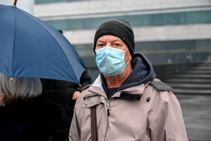 Čovjek sa medicinskom maskom tokom pandemije Covid-19. Stariji muškarac nosi masku za lice kao zaštitu od korona virusa.