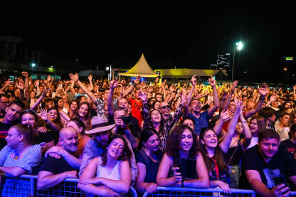 Publika ispred bine na muzičkom festivalu. Grupa mladih na koncertu.
