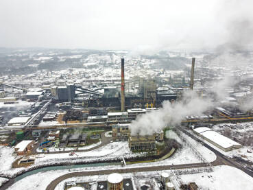 Dimnjaci u tvornici ispuštaju zagađenje u okoliš. Industrijsko onečišćenje zraka iz dimnjaka. Nezdravi i opasni dim iz dimnjaka u industrijskoj zoni tokom zime. Industrijski kompleks. Fabrika.