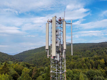 GSM i radio telekomunikacioni toranj na planini, snimak dronom. Toranj za mobilnu telefoniju. Bazna GSM stanica. Bežični komunikacioni antenski predajnik.