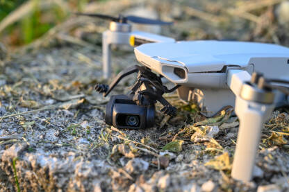Srušen i oštećen dron. Slomljena kamera drona na asfaltnom putu. Dron pao na zemlju. Nesreća tokom leta.