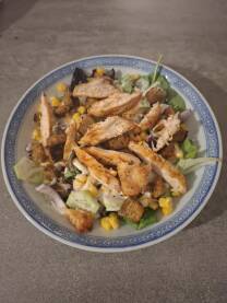 Jelo pileća Salata sa krastavcem i kukuruzom u tanjiru